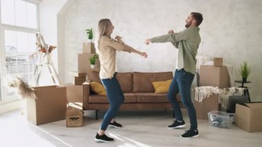 New Home 'da çift dansı. Çift yeni Düz Danslı Mutlu Taşındı. İlk Ev Alışverişini Kutlayan Çift.
