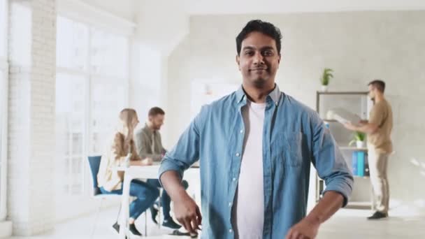 Indian Man Standing Hands SCross in Creative Office. Pracovní den v kanceláři. Tvůrčí tým pracuje. Shot on RED — Stock video