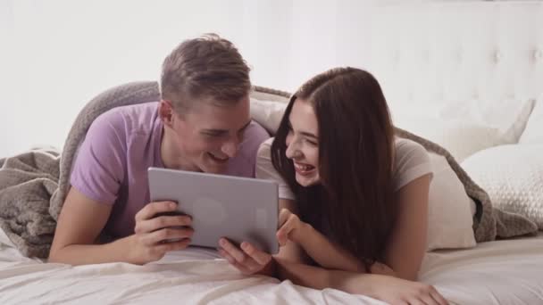 Couple Using Tablet in Bed. Couple With Tablet in Bed Having Fun. Shopping Online. — Stock Video
