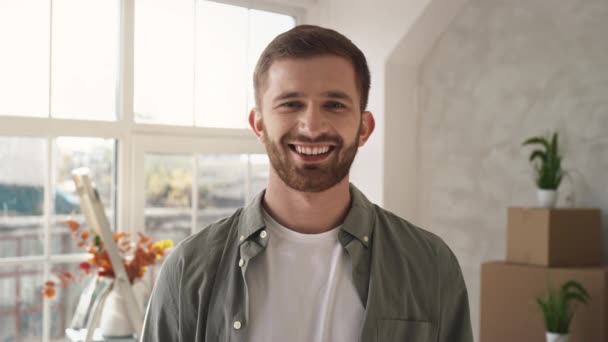 Portret van een jonge man die glimlachend een medisch masker opzet. Geschoten op rood. — Stockvideo