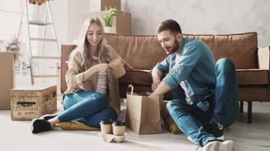 Evde yemek yiyen bir çift. Bir çift New Home 'a taşınmış. Evde Fast Food. Kırmızı ışıkta.