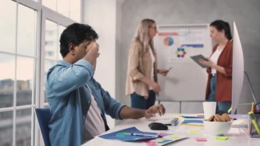 Hintli Adam Yaratıcı Ofis 'te bilgisayar üzerinde çalışmaktan yoruldu. Ofiste Sunum Konuşan Kızlar. Yaratıcı Ofis İşleri. Hintli adam gözlerini ovuşturuyor. Kırmızı ışıkta.