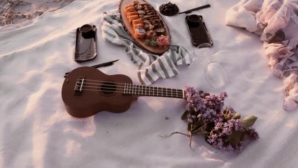 Picnic romántico en la playa. Sushi romántico preparado. Comida y bebida al atardecer. — Vídeo de stock