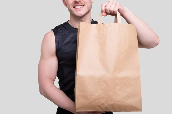 Sportman håller matsäck. Man med papperspåse i händerna. Närbild papperspåse i händerna. Hälsosam mat, hälsosam mat, Sport Concept — Stockfoto