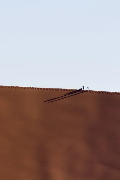 Mensen op een rode Duin in de Namib woestijn, in Sossusvlei, Namibië — Stockfoto