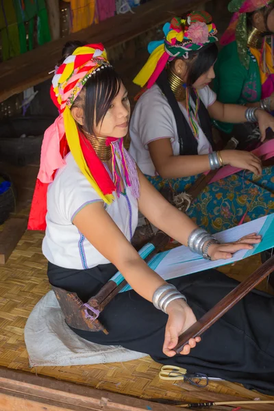 Girl of the tribe Kayan (Padaung) in traditional clothing works to weaving cotton in his village near Lake Inle — Stock Photo, Image