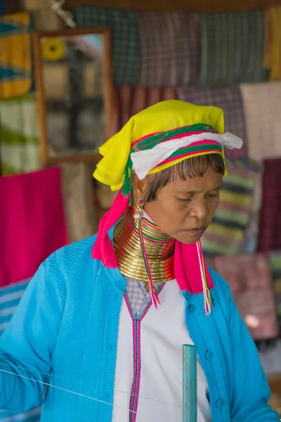Woman of the tribe Kayan (Padaung) in traditional clothing works to weaving cotton in his village near Lake Inle — Stockfoto