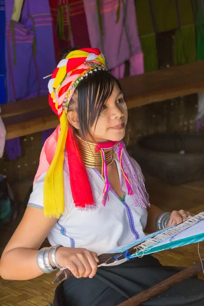 Girl of the tribe Kayan (Padaung) in traditional clothing works to weaving cotton in his village near Lake Inle — Stock Photo, Image