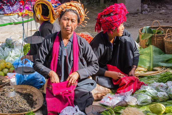 Three unidentified women in traditional dress sells vegetables at market of Inn Dain Khone Village, on Inle Lake. — Stock Photo, Image