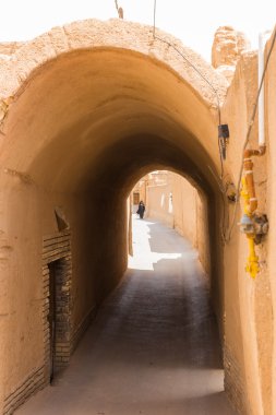 kadın yazd Iran dar sokaklarında aşağı yürüyor