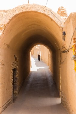 kadın yazd Iran dar sokaklarında aşağı yürüyor
