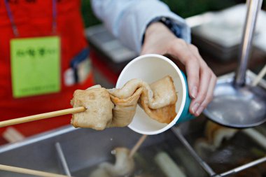 Bir şefin elinin bir kase yemek tutarken yakın plan çekimi.