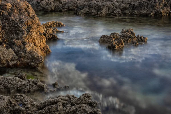 Güneş doğarken deniz suyu dokuları ve kayalar. Bahar geldi. Seçici odaklan.
