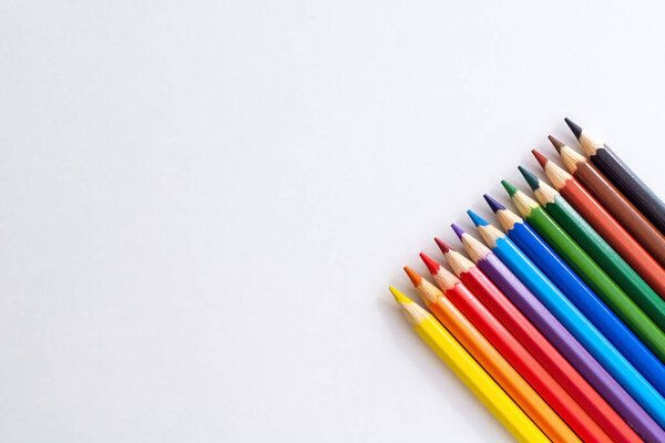 Bright colored pencils for drawing on a white isolated background with an empty space for a signature. Pastel colors of new pencils.