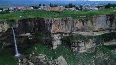 Kartal bir dağ geçidinin ve şelalelerin üzerinden uçar. Büyük bir yırtıcı kuş uçurumun üzerinde süzülüyor. Çimenli kanyonda birkaç şelale. Yeşil kayalar arasında doğa manzaralı seyahat tatili