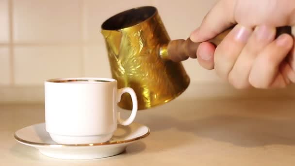 Koffie uit cezve in de beker gieten. — Stockvideo