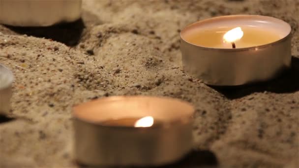 Twee brandende kaarsen in het zand in de kerk — Stockvideo