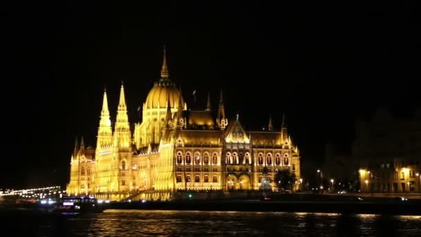 Parlement in Boedapest bij nacht tijdens het zeilen op een boot op de rivier de Donau. — Stockvideo