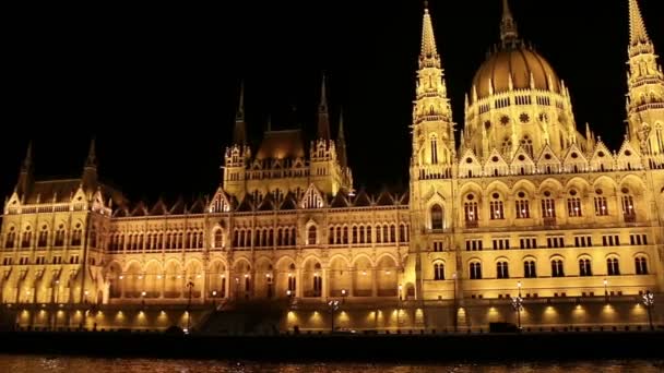 Κοινοβουλίου στη Βουδαπέστη τη νύχτα ενώ πλέουν σε μια βάρκα στον ποταμό Δούναβη. — Αρχείο Βίντεο