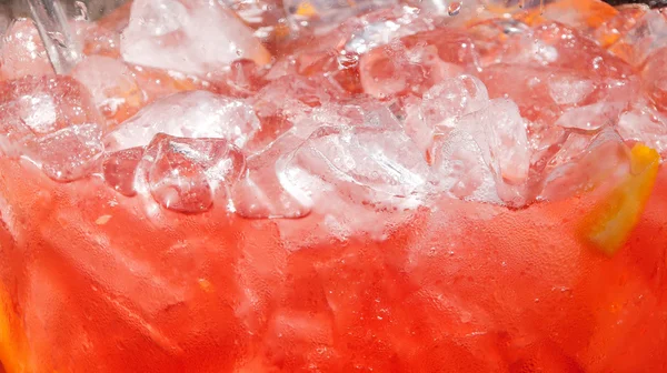 Bakgrund av röd drink med citron och is. — Stockfoto