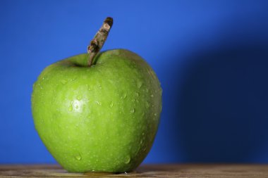 Yeşil elma suyu ile mavi arka plan, makro damla