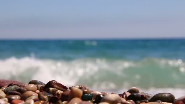 A hullámok a tenger, a gyönyörű kavicsos strand a háttérben. — Stock videók