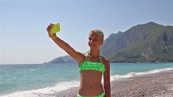 Fiatal lány, hogy egy selfie a tengerparton, a Földközi-tenger — Stock videók
