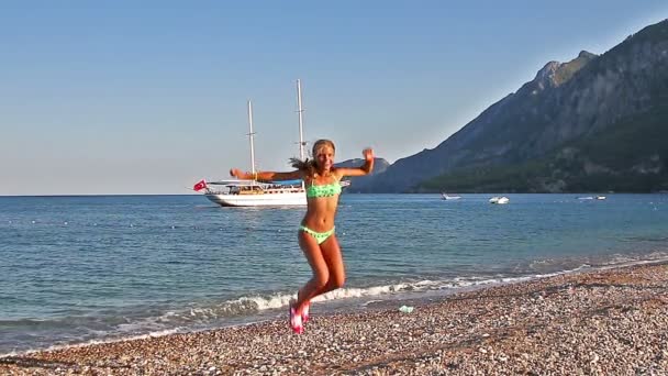 Glad ung flicka hoppa på stranden. Slow motion. — Stockvideo