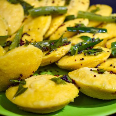 Dhokla Khaman tabakta kişniş süsleme, taze ve sıcak sarımsı khaman dhokla ile ev yapımı baharatlar, Hindistan, ev yapımı dhokla