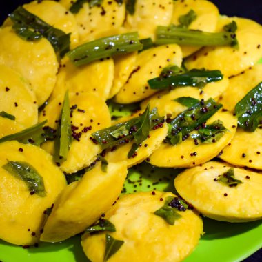 Dhokla Khaman tabakta kişniş süsleme, taze ve sıcak sarımsı khaman dhokla ile ev yapımı baharatlar, Hindistan, ev yapımı dhokla