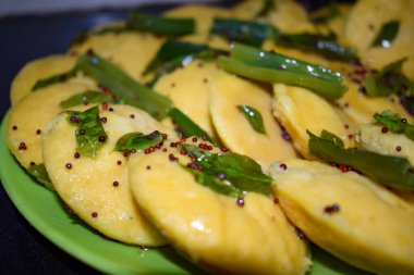 Dhokla Khaman tabakta kişniş süsleme, taze ve sıcak sarımsı khaman dhokla ile ev yapımı baharatlar, Hindistan, ev yapımı dhokla