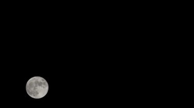 Moon Timelapse, Stock zamanaşımı: Dolunay karanlık gökyüzünde yükseliyor, gece vakti. Dolunay zamanı, gece karanlığında karanlık gökyüzünde ay ışığıyla birlikte kaybolur. Yüksek kaliteli beleş video kaydı veya zaman ayarlı