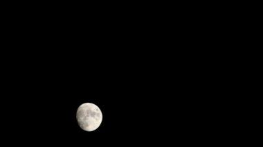 Moon Timelapse, Stock zamanaşımı: Dolunay karanlık gökyüzünde yükseliyor, gece vakti. Dolunay zamanı, gece karanlığında karanlık gökyüzünde ay ışığıyla birlikte kaybolur. Yüksek kaliteli beleş video kaydı veya zaman ayarlı