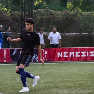 Yeni Delhi, Hindistan - 19 Temmuz 2019 - Kötü bir futbol sahasında bölgesel Derby şampiyonasında yerel futbol takımının futbolcuları. Stadyumun çimen yeşili sahasında sıcak bir futbol maçı var.