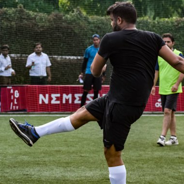 Yeni Delhi, Hindistan - 19 Temmuz 2019 - Kötü bir futbol sahasında bölgesel Derby şampiyonasında yerel futbol takımının futbolcuları. Stadyumun çimen yeşili sahasında sıcak bir futbol maçı var.
