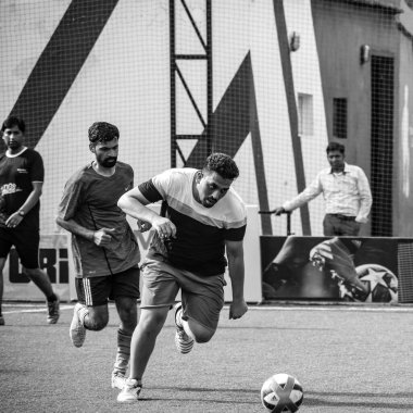 Yeni Delhi, Hindistan - 19 Temmuz 2019 - Kötü bir futbol sahasında bölgesel Derby şampiyonasında yerel futbol takımının futbolcuları. Stadyumun çimen yeşili sahasında sıcak bir futbol maçı var.