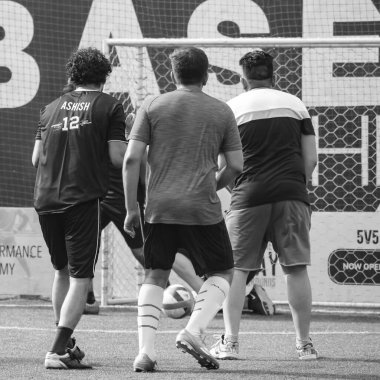 Yeni Delhi, Hindistan - 19 Temmuz 2019 - Kötü bir futbol sahasında bölgesel Derby şampiyonasında yerel futbol takımının futbolcuları. Stadyumun çimen yeşili sahasında sıcak bir futbol maçı var.