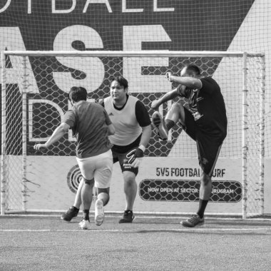 Yeni Delhi, Hindistan - 19 Temmuz 2019 - Kötü bir futbol sahasında bölgesel Derby şampiyonasında yerel futbol takımının futbolcuları. Stadyumun çimen yeşili sahasında sıcak bir futbol maçı var.