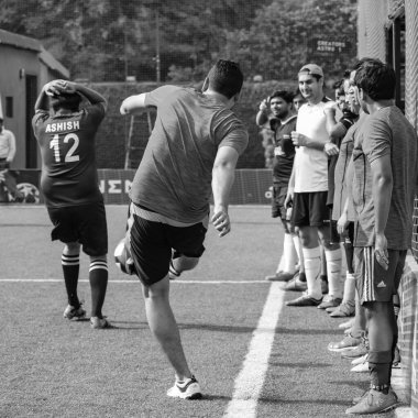 Yeni Delhi, Hindistan - 19 Temmuz 2019 - Kötü bir futbol sahasında bölgesel Derby şampiyonasında yerel futbol takımının futbolcuları. Stadyumun çimen yeşili sahasında sıcak bir futbol maçı var.