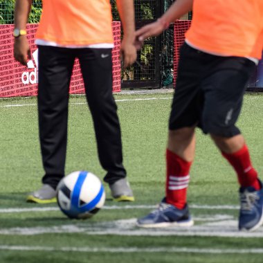 Yeni Delhi, Hindistan - 19 Temmuz 2019 - Kötü bir futbol sahasında bölgesel Derby şampiyonasında yerel futbol takımının futbolcuları. Stadyumun çimen yeşili sahasında sıcak bir futbol maçı var.