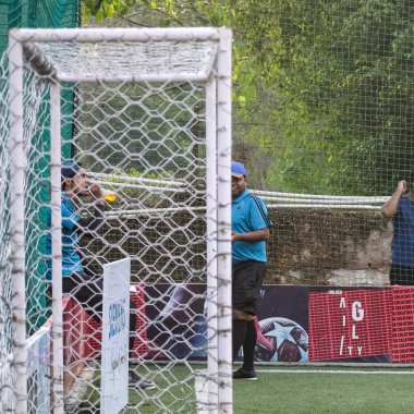 Yeni Delhi, Hindistan - 01 Temmuz 2018 - Kötü bir futbol sahası üzerinde bölgesel Derby şampiyonasında yerel futbol takımının futbolcuları. Stadyumun çimen yeşili sahasında sıcak bir futbol maçı var.