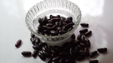 Siyah gram ham puls tohumları kristal berraklığında beyaz arka planda izole edilmiş, Hint Punjabi 'sinin favori Siyah Chana' sı masada, Raw Black Chana beyaz arka planda
