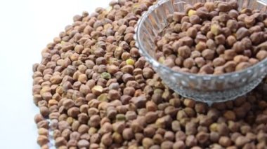 Siyah gram ham puls tohumları kristal berraklığında beyaz arka planda izole edilmiş, Hint Punjabi 'sinin favori Siyah Chana' sı masada, Raw Black Chana beyaz arka planda