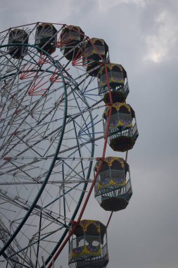Delhi, Hindistan 'da Dussehra Mela sırasında çok renkli Dev Tekerlek' in yakın çekimi. Dev tekerlek salıncağının alt görüntüsü. Akşam vakti renkli kamaraları olan dönme dolap..