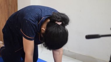Evde yoga yapan genç Hintli bir kadın çevrimiçi yoga seansında güzel bir kız temel yoga pozisyonunda Asyalı bir kadın kapalı alanda yoga yapıyor. 