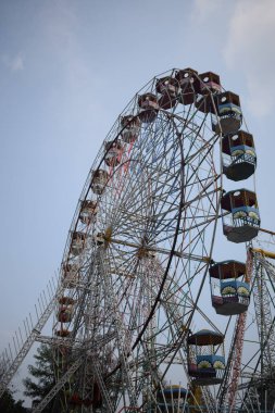 Delhi, Hindistan 'da Dussehra Mela sırasında çok renkli Dev Tekerlek' in yakın çekimi. Dev tekerlek salıncağının alt görüntüsü. Akşam vakti renkli kamaraları olan dönme dolap..