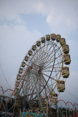 Delhi, Hindistan 'da Dussehra Mela sırasında çok renkli Dev Tekerlek' in yakın çekimi. Dev tekerlek salıncağının alt görüntüsü. Akşam vakti renkli kamaraları olan dönme dolap..