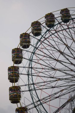Delhi, Hindistan 'da Dussehra Mela sırasında çok renkli Dev Tekerlek' in yakın çekimi. Dev tekerlek salıncağının alt görüntüsü. Akşam vakti renkli kamaraları olan dönme dolap..