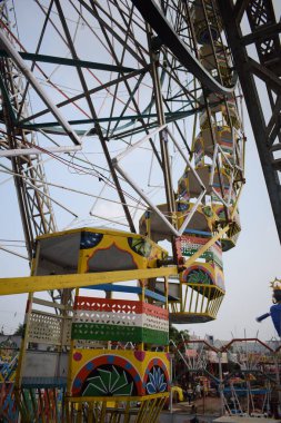 Delhi, Hindistan 'da Dussehra Mela sırasında çok renkli Dev Tekerlek' in yakın çekimi. Dev tekerlek salıncağının alt görüntüsü. Akşam vakti renkli kamaraları olan dönme dolap..