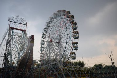 Delhi, Hindistan 'da Dussehra Mela sırasında çok renkli Dev Tekerlek' in yakın çekimi. Dev tekerlek salıncağının alt görüntüsü. Akşam vakti renkli kamaraları olan dönme dolap..
